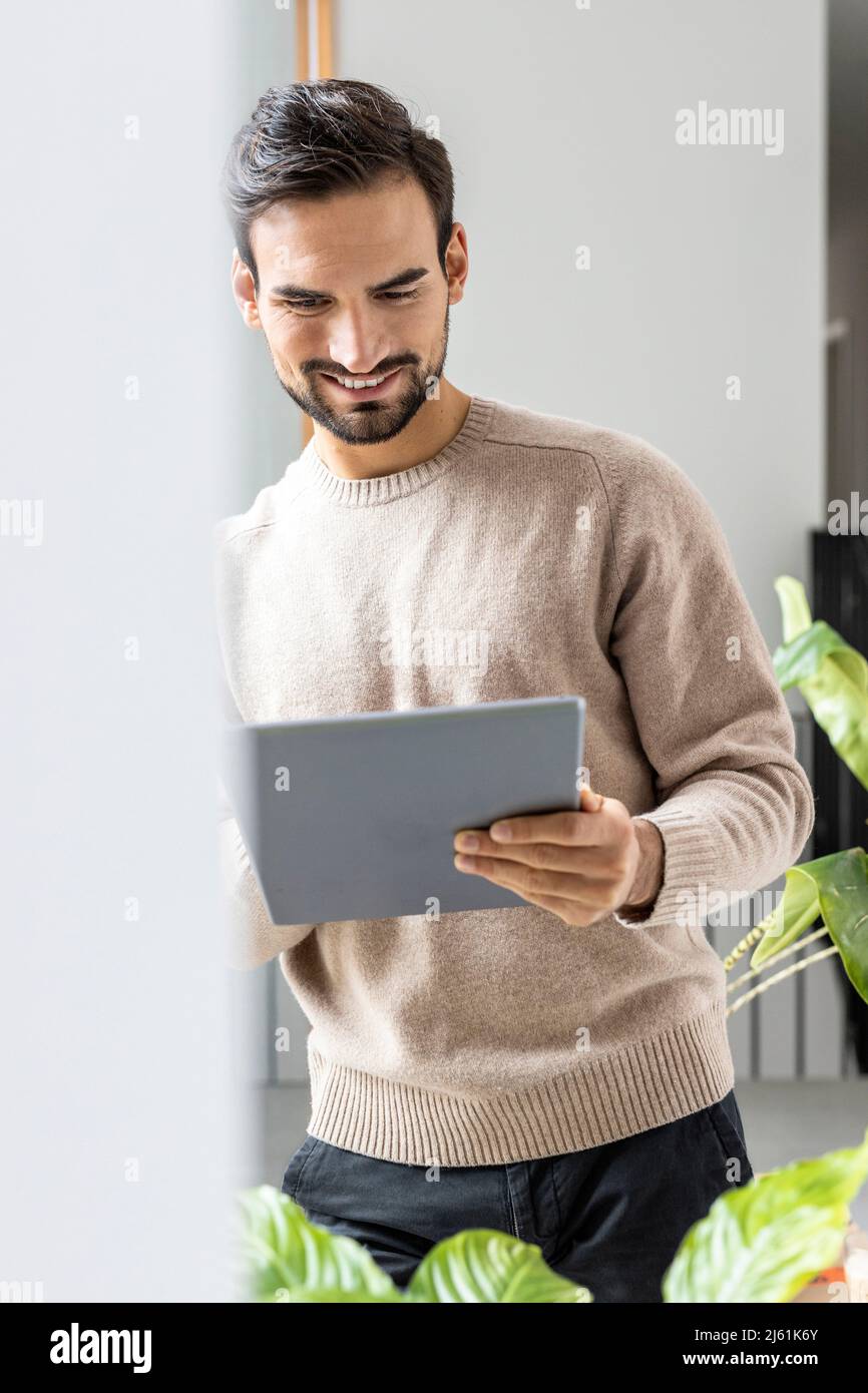 Smiling man using tablet PC at home Stock Photo