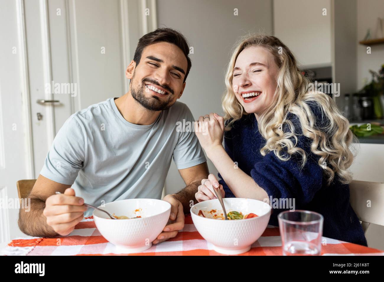 Happy couple enjoying meal at home Stock Photo