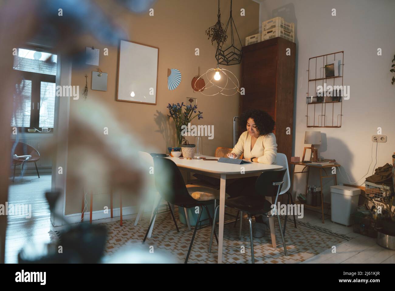 Woman using tablet PC at dining table Stock Photo