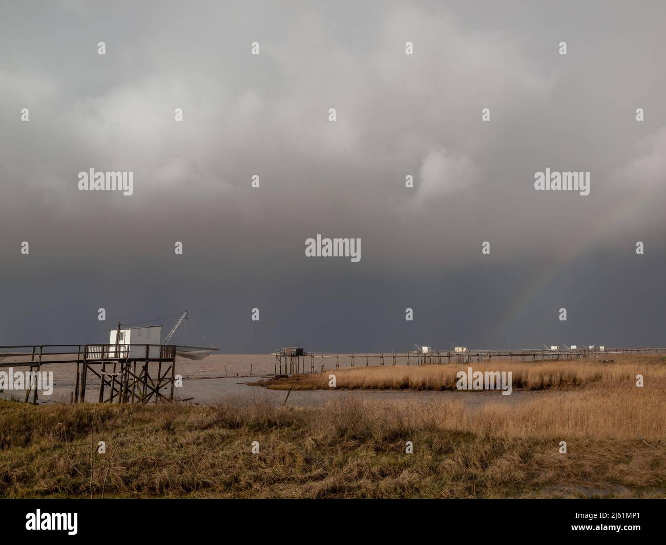 Stormy weather on Atlantic west coast La Rochelle, Charente Maritime, France dark rain clouds over fishing huts along shoreline Stock Photo