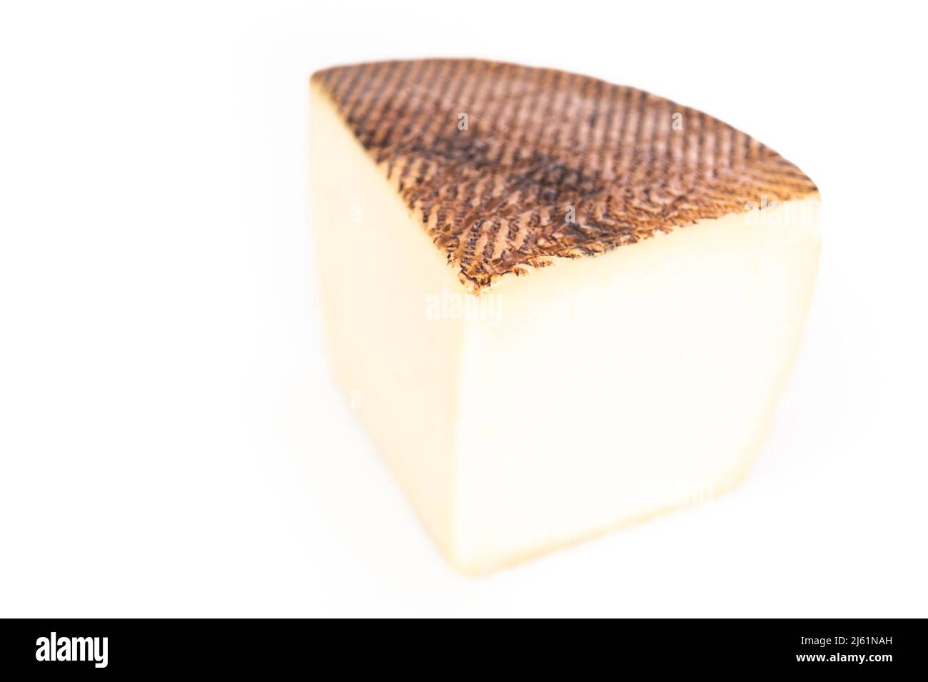 Large slice of aged Manchego cheese on a white background Stock Photo ...