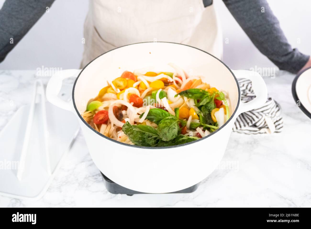 Preparing one pot pasta in enameled cast iron dutch oven Stock Photo Alamy