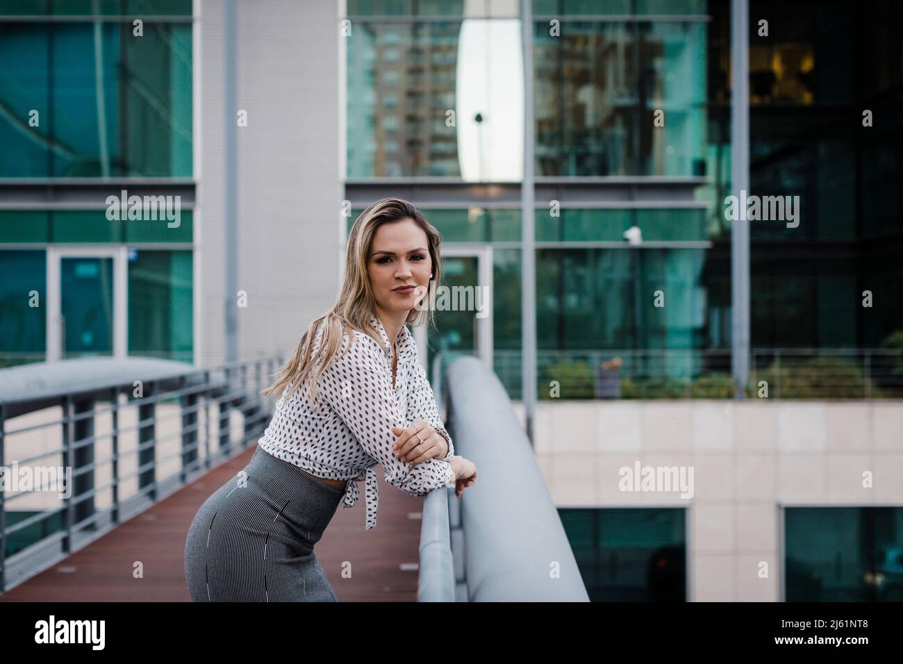 Confident businesswoman leaning on railing Stock Photo - Alamy