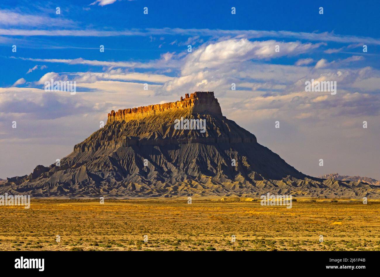 This is a late-afternoon view of a landmark formation called Factory Butte in an isolated area of Wayne County Utah, USA. Stock Photo