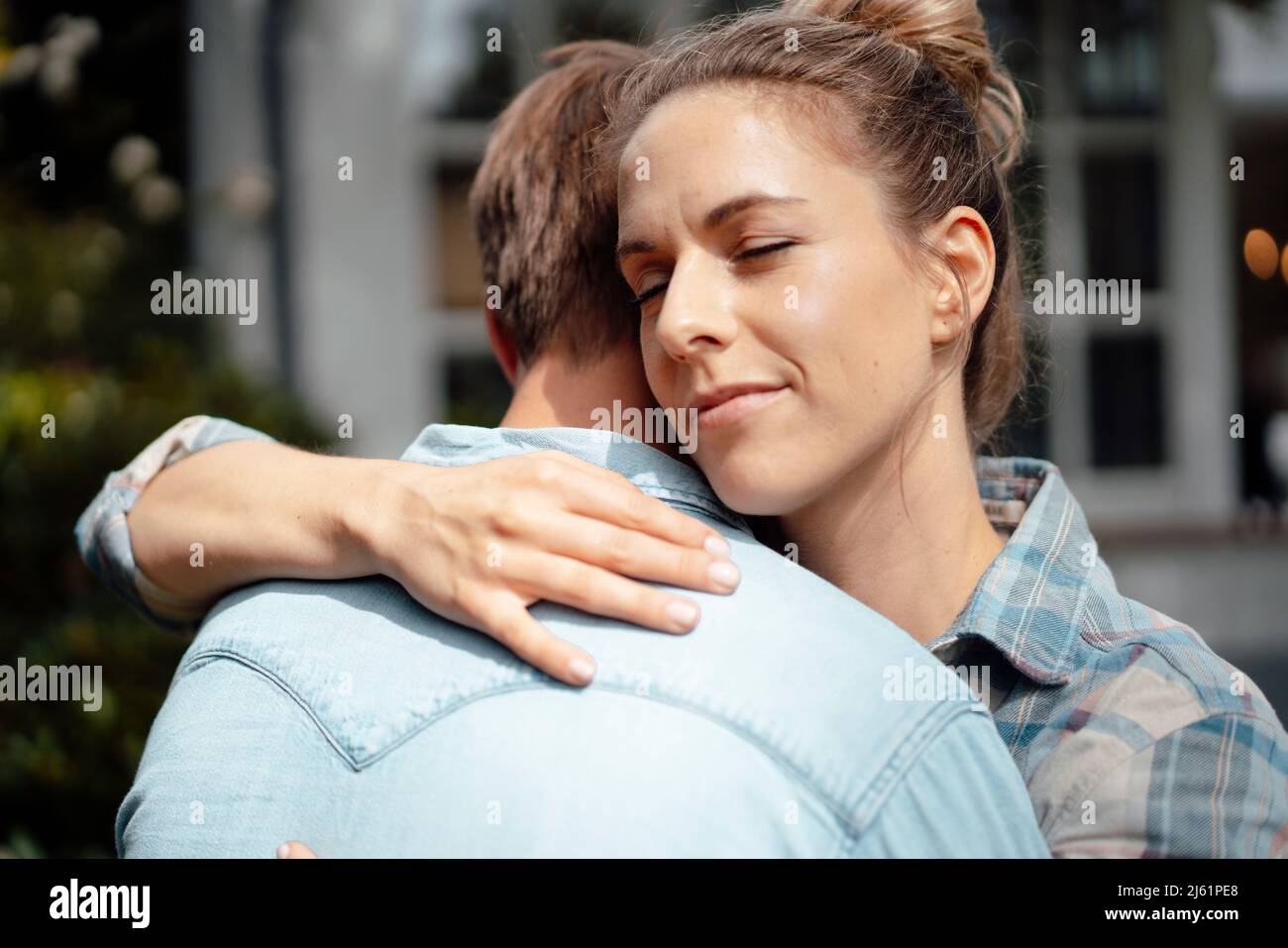 Blond woman with eyes closed hugging boyfriend Stock Photo - Alamy