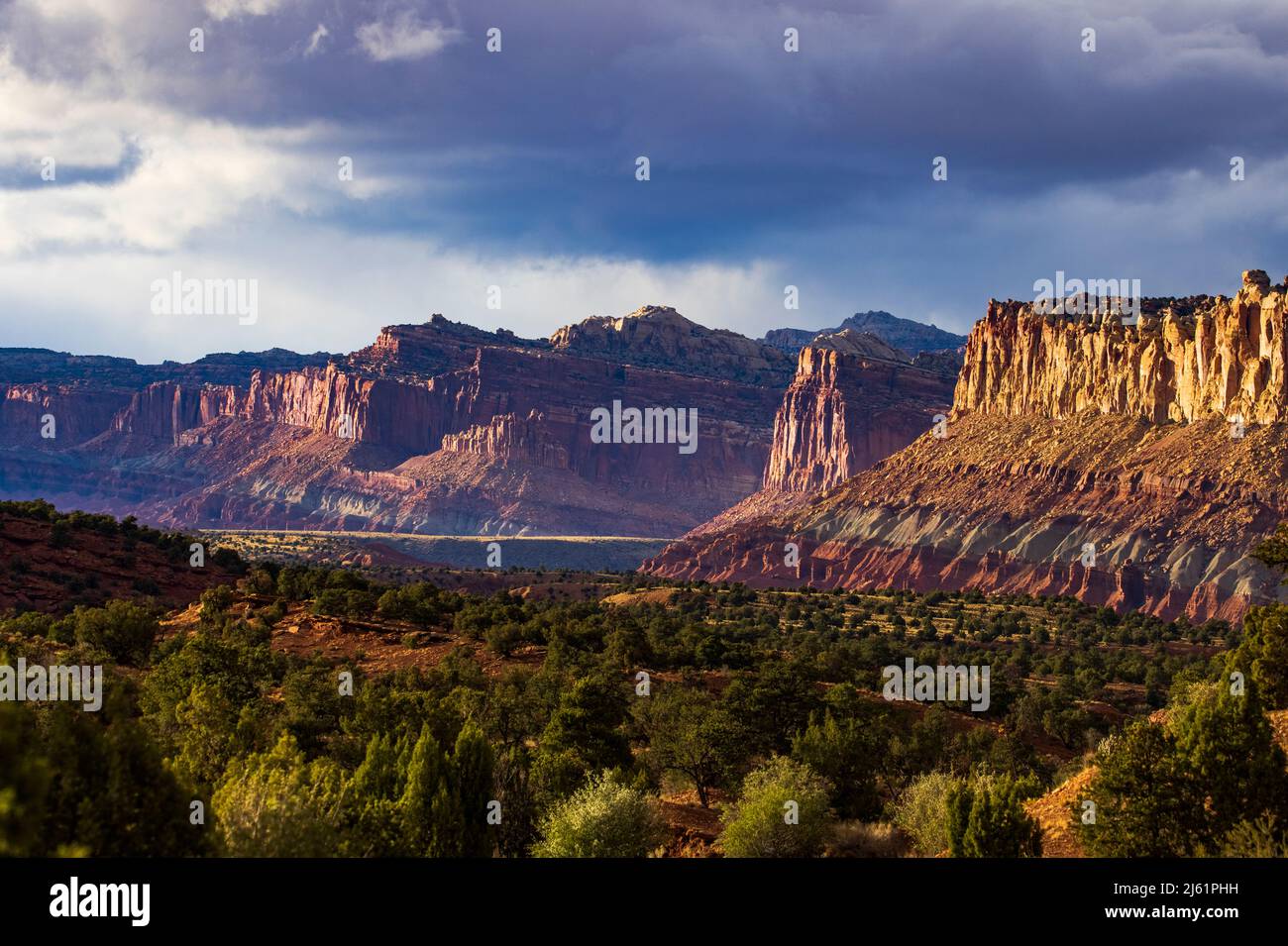 This is a late afternoon view of the majestic red rock cliffs of Capitol Reef National Park, Torrey, Wayne County, Utah, USA. This view looks north fr Stock Photo