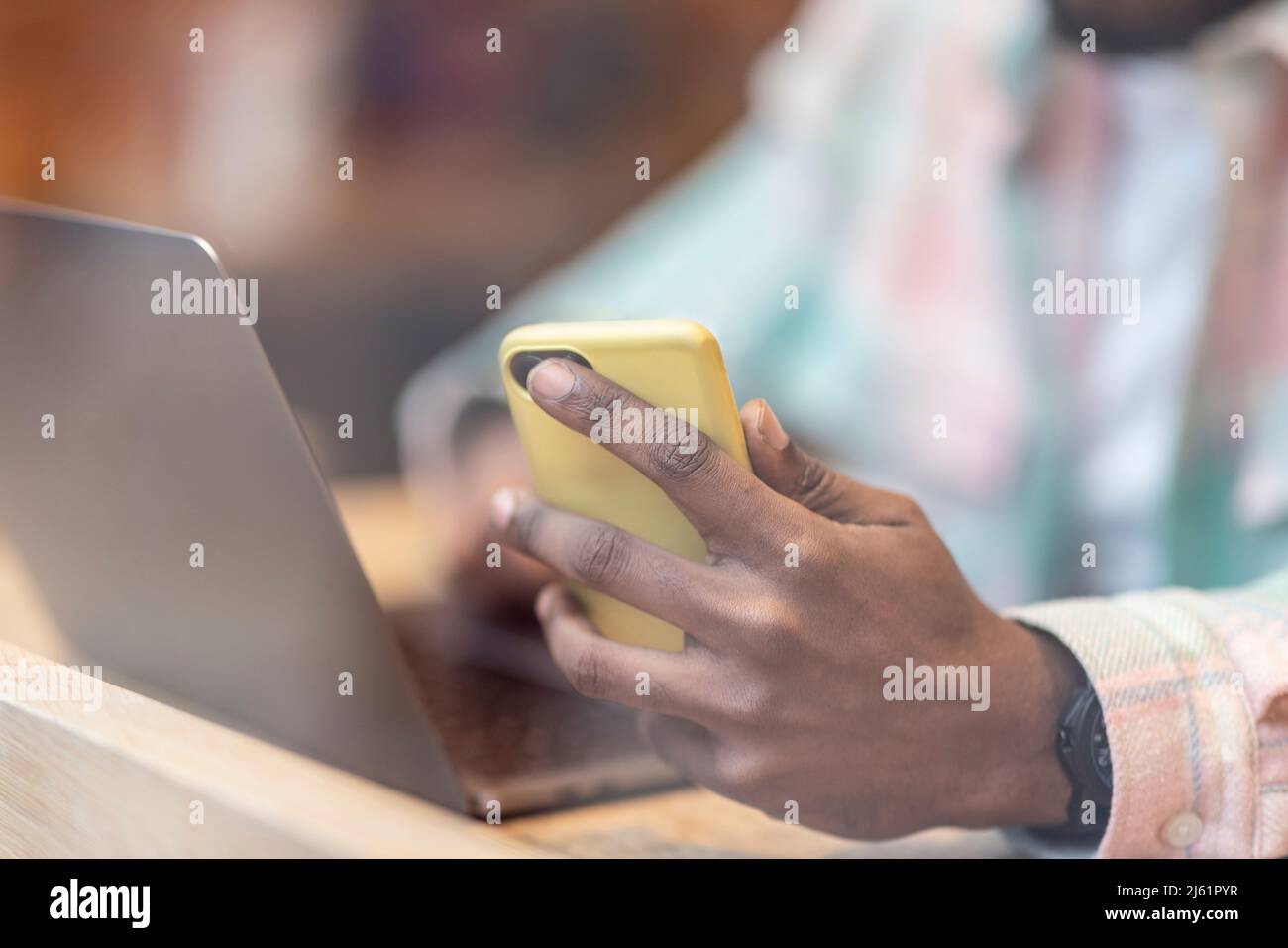 Man with laptop using smart phone at cafe Stock Photo