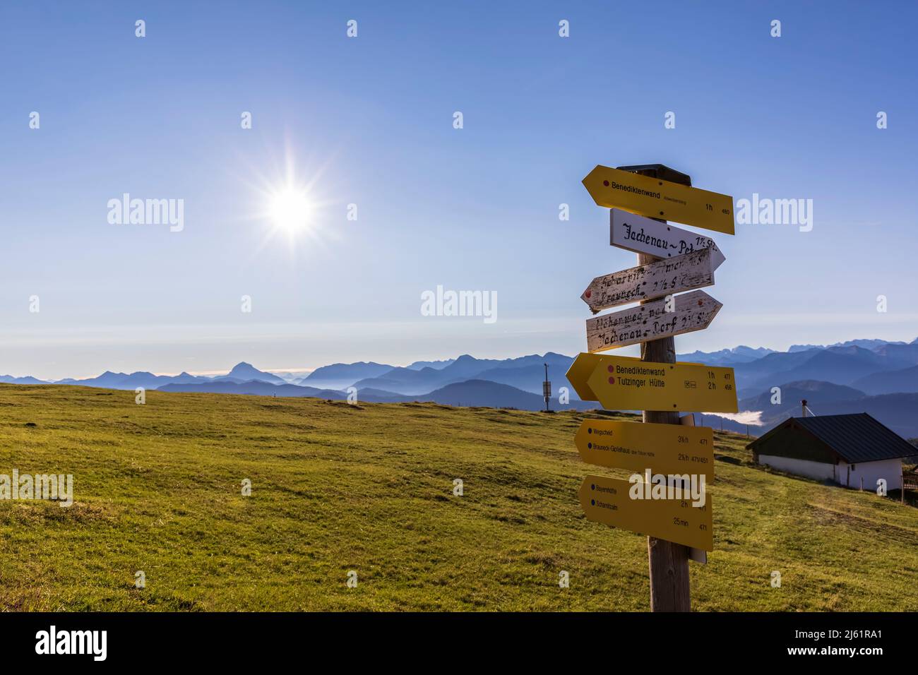 Directional sign in Bavarian Prealps at foggy sunrise Stock Photo