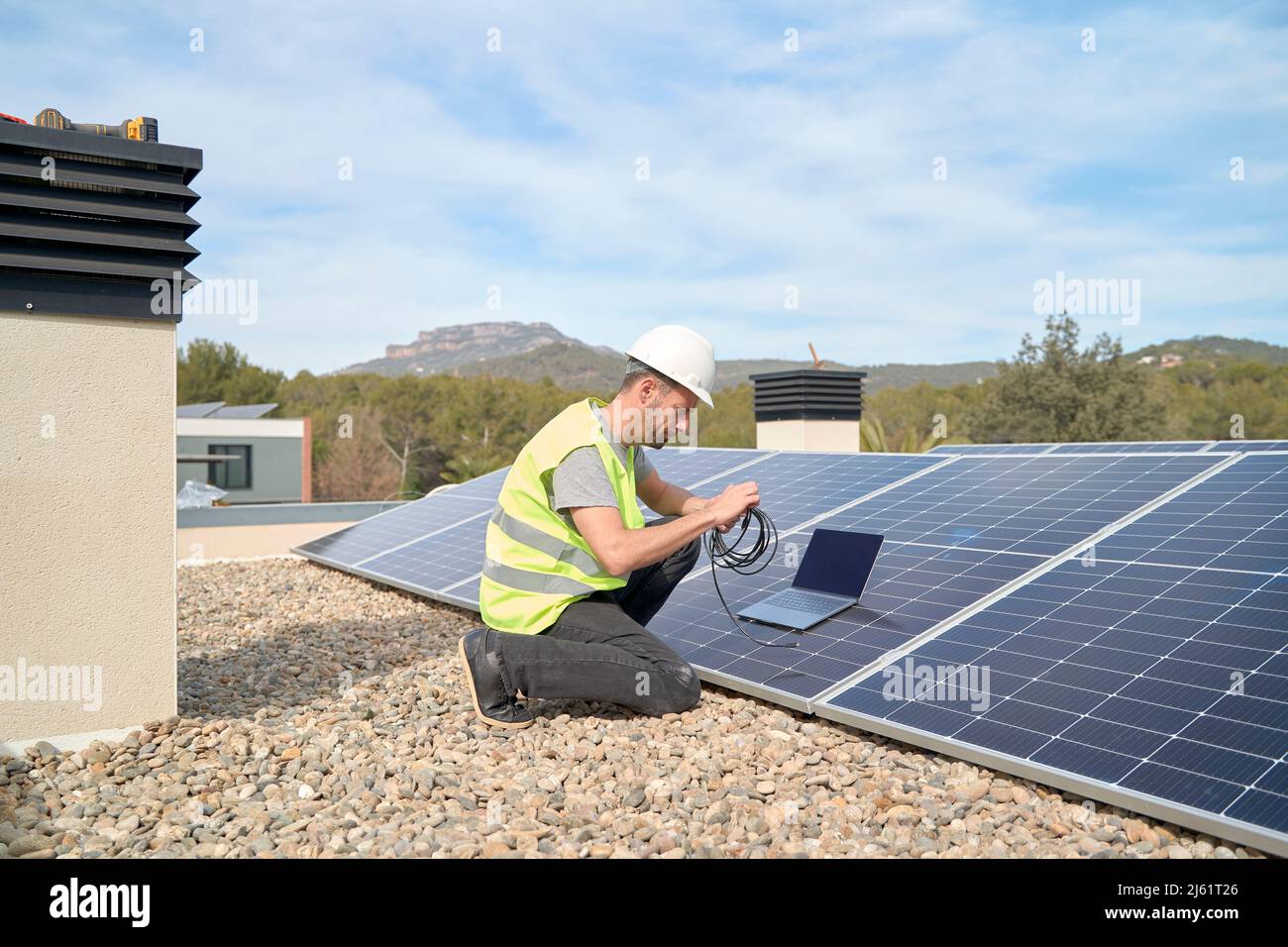 Engineer with laptop and cable installing solar panels on rooftop Stock ...