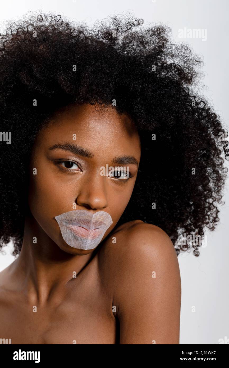 Beautiful young woman with lip mask against white background Stock Photo