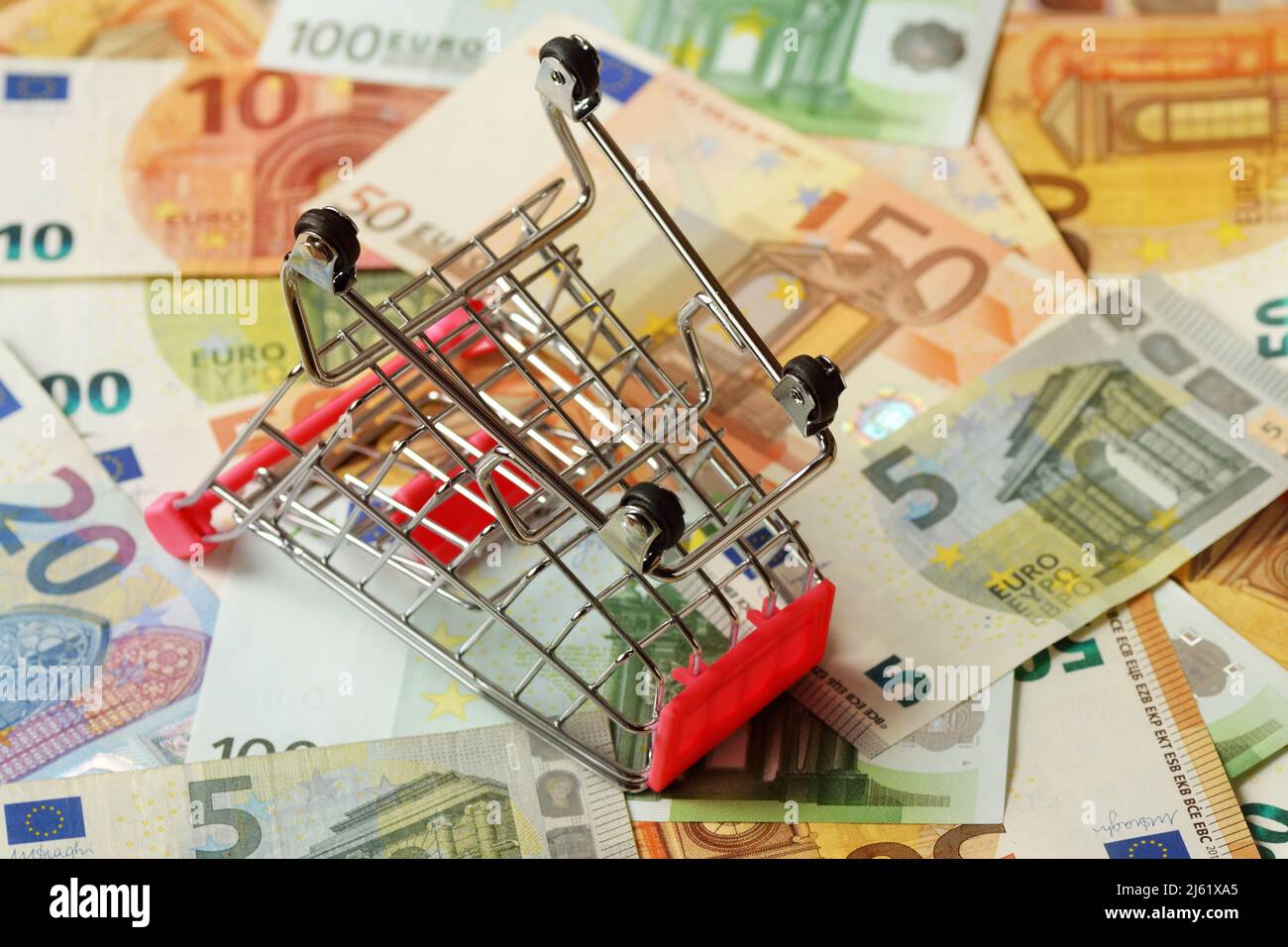 Empty inverted shopping cart on euro money background - Concept of purchasing crisis Stock Photo