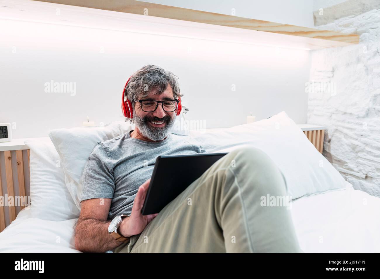 Happy man sitting on bed hi-res stock photography and images - Alamy