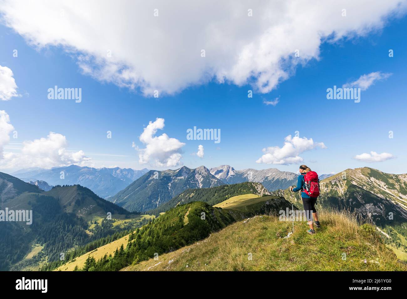 Woman with hiking pole standing on mountain Stock Photo