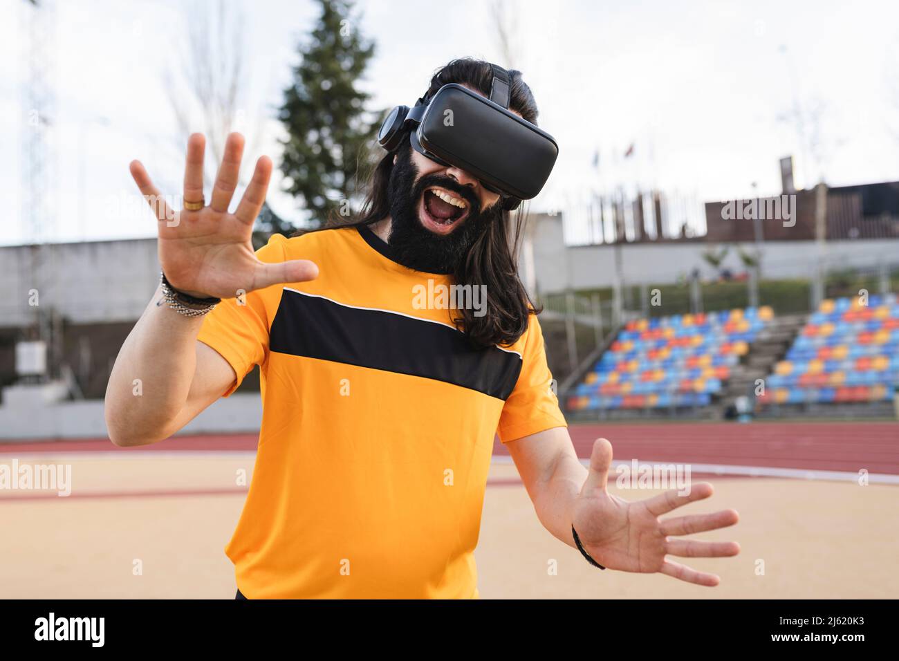 Bearded man wearing virtual reality simulator gesturing with mouth open Stock Photo