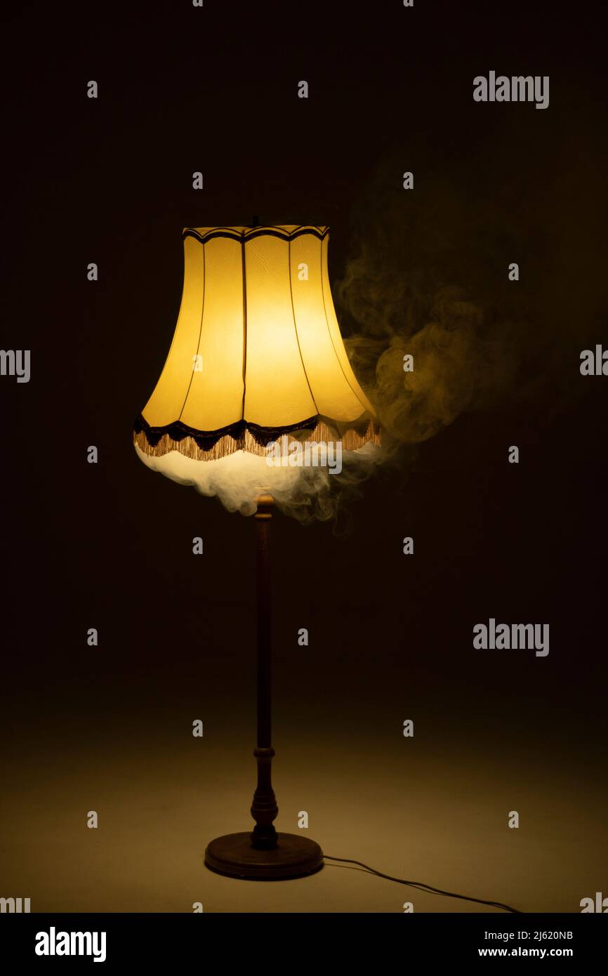 Illuminated smoky lamp in dark room Stock Photo