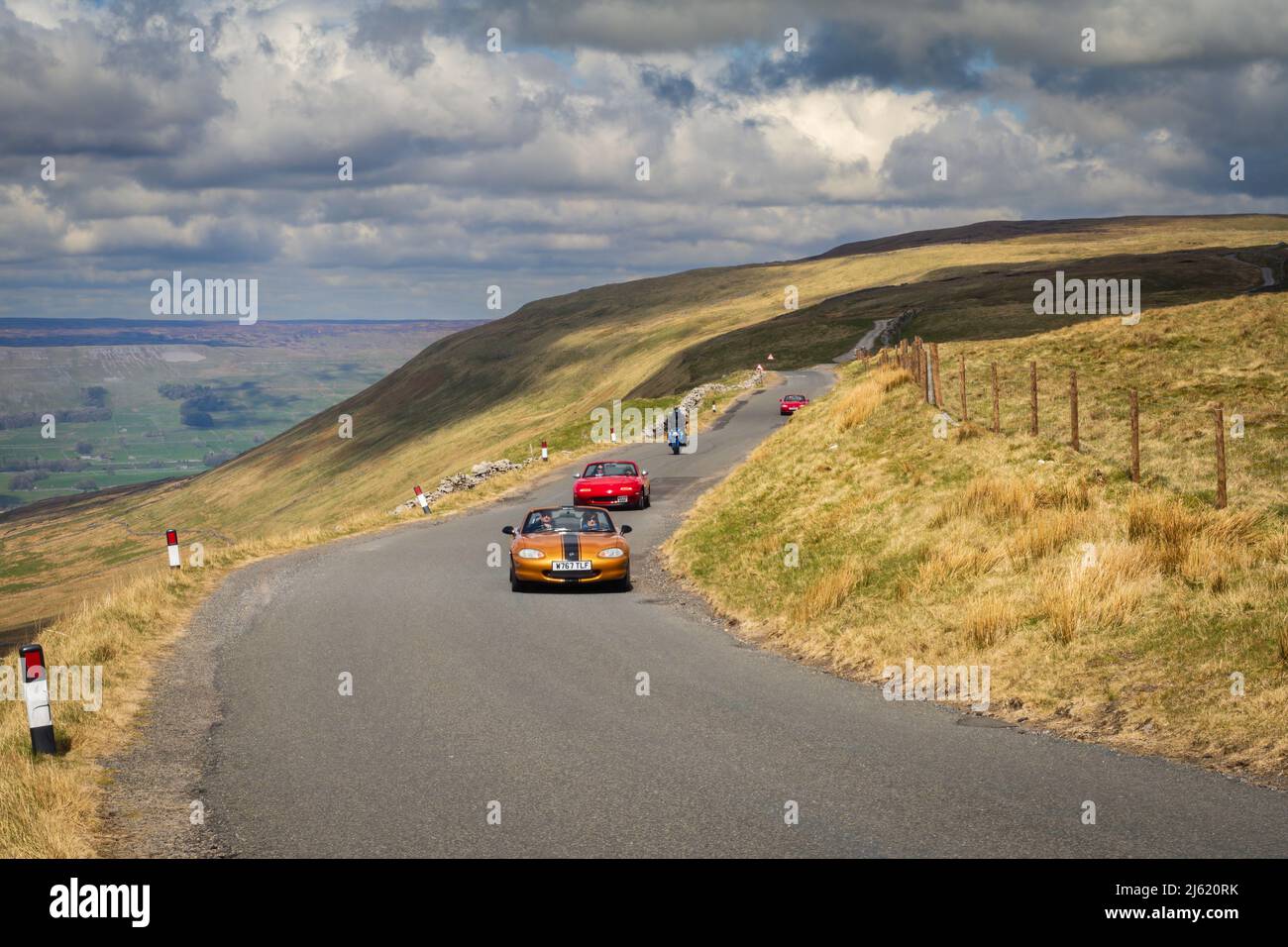 24.04.2022 Hawes, North Yorkshire, UK.Vintage cars drive up Bergmans Rd above Hawes in the Yorkshire Dales Stock Photo