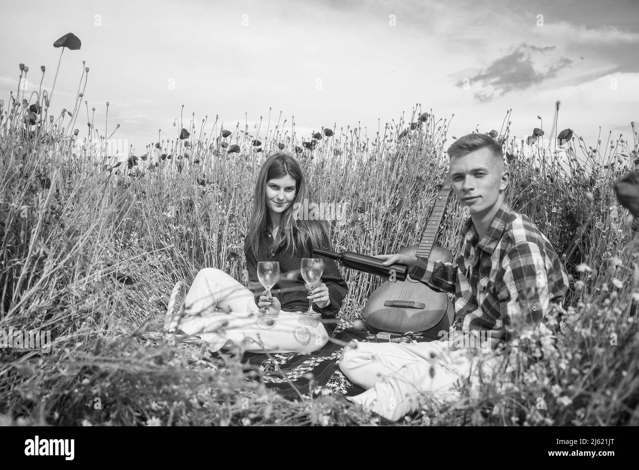 love and romance. opium. spring countryside. lovers with guitar in flower field. music Stock
