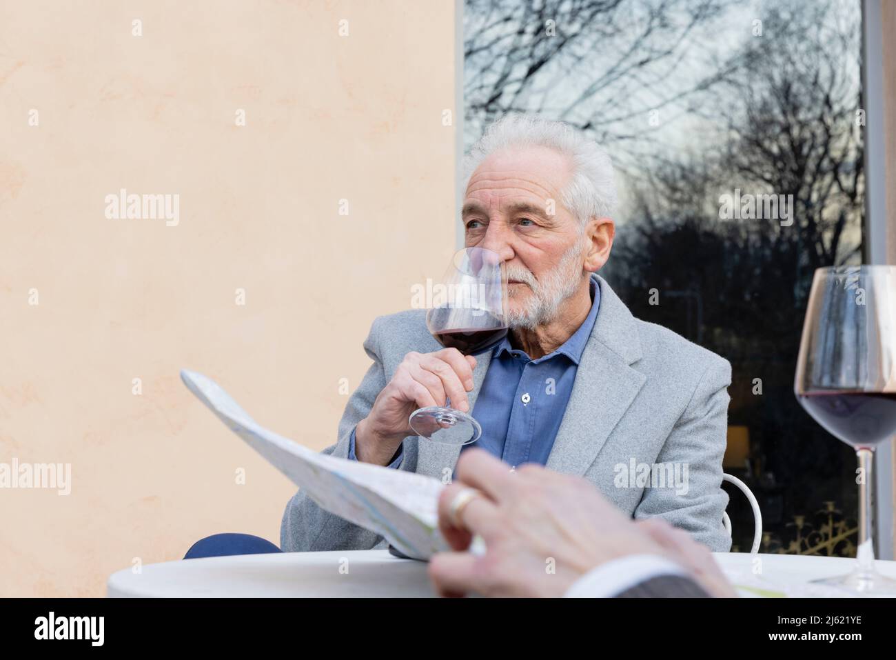 Senior man drinking wine sitting at table Stock Photo