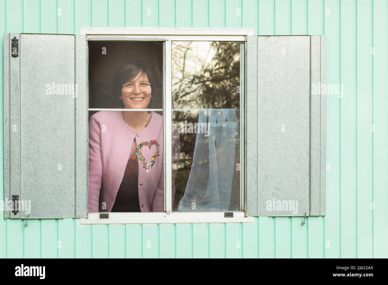 Smiling woman looking through window from trailer Stock Photo
