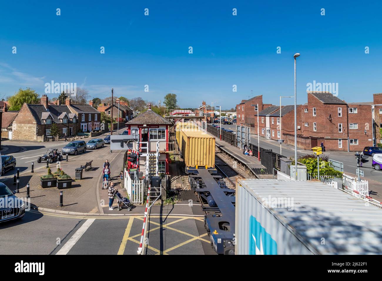 Container train going through Oakham station on a afternoon, looking