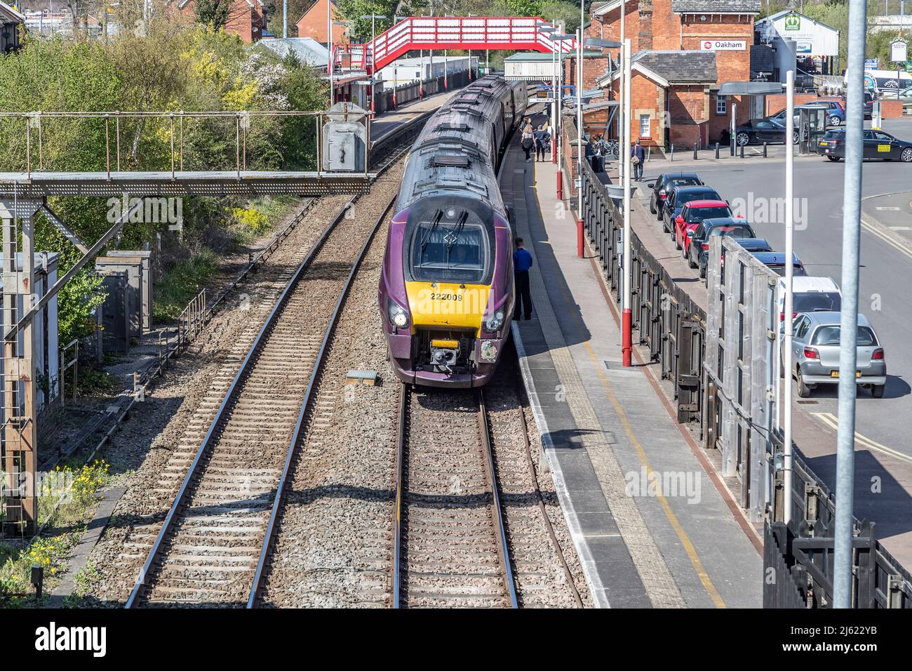 Diesel-electric passenger train leaving Oakham station, looking down from the foot bridge over then tracks, Rutland, Leicester, England, UK. Stock Photo