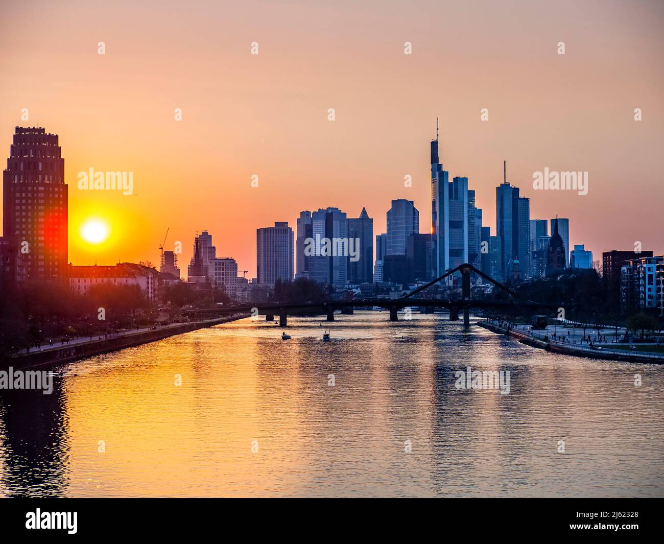 Germany, Hesse, Frankfurt, River Main canal at sunset with bridge and downtown skyscrapers in background Stock Photo