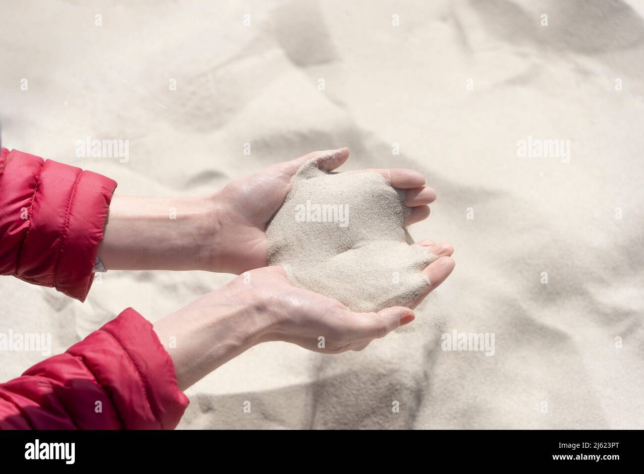 Hands of woman with sand on sunny day Stock Photo