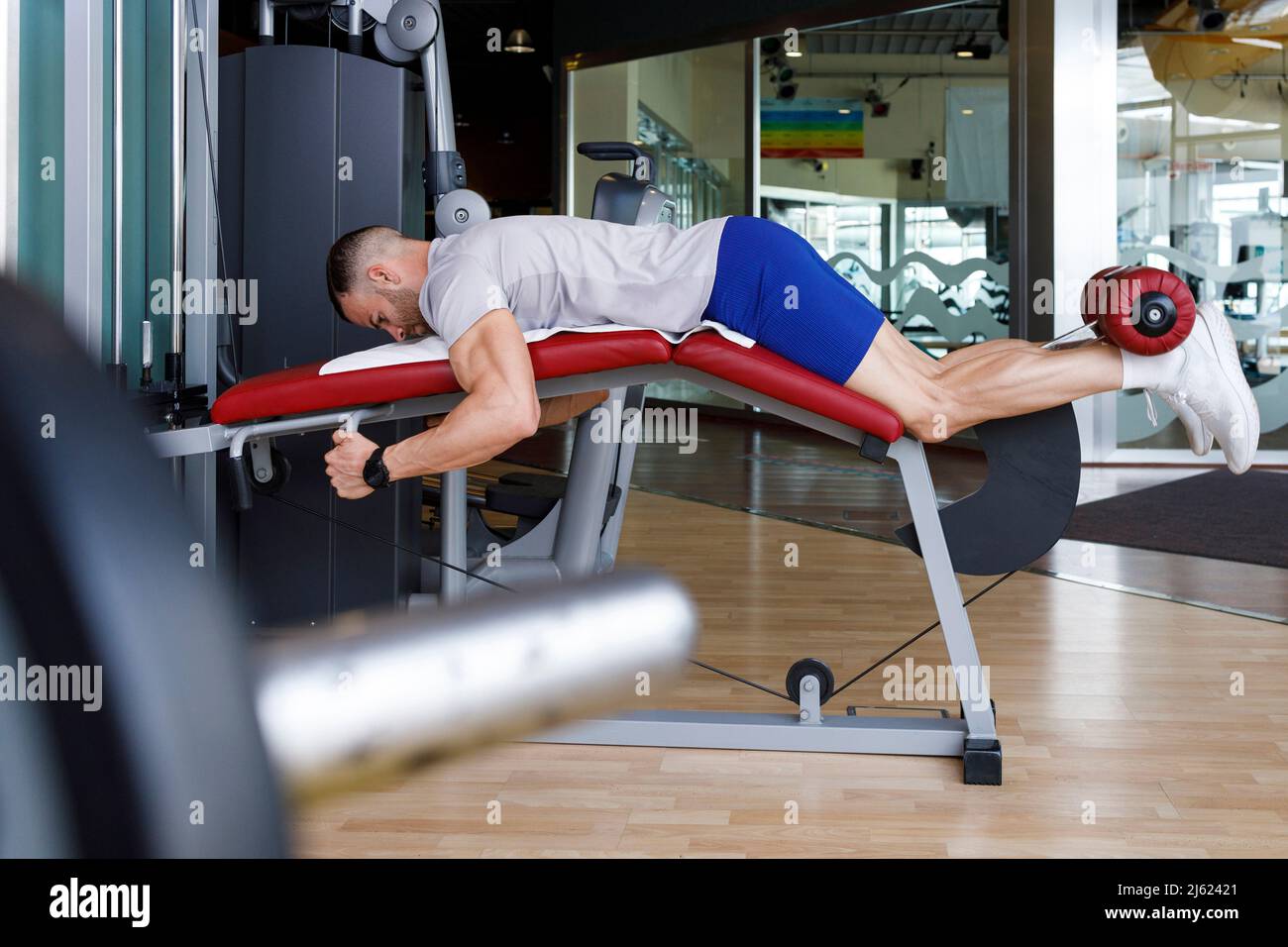 Man doing leg exercise in gym Stock Photo