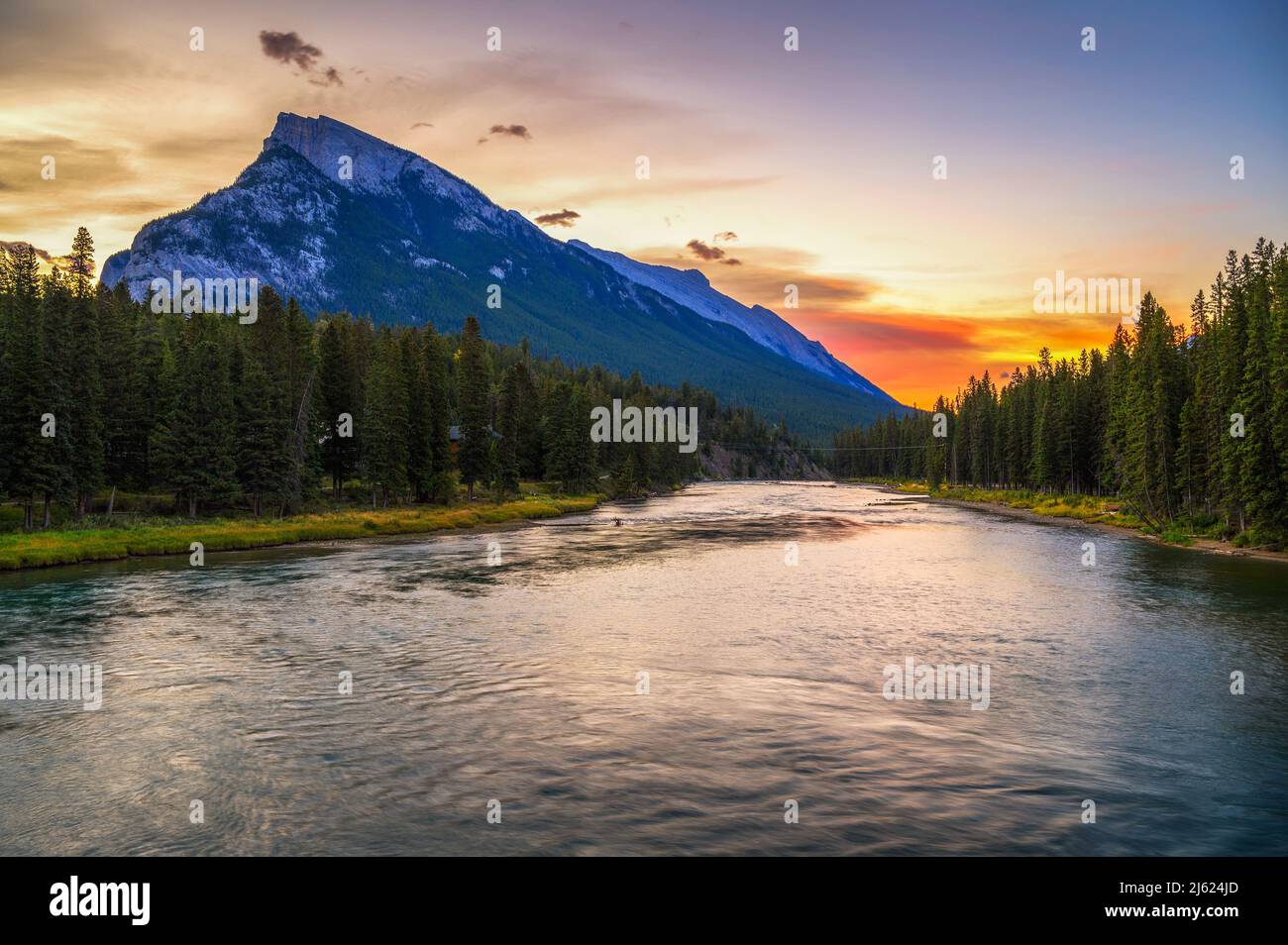 Sunrise above Bow River and Mount Rundle from Banff Pedestrian Bridge in Canada Stock Photo
