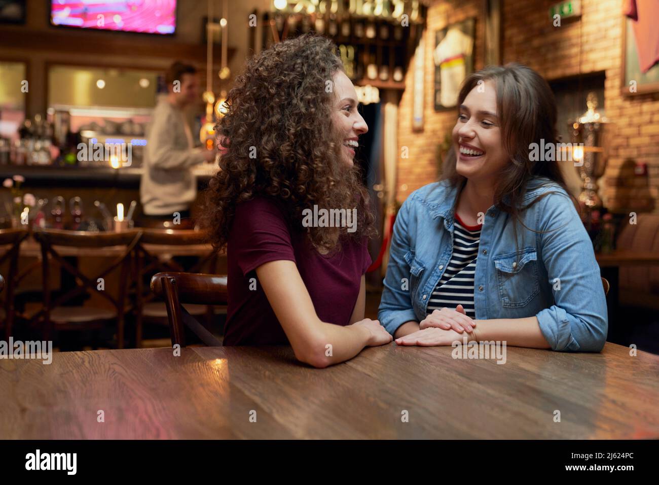 Two female friends talking in a pub Stock Photo