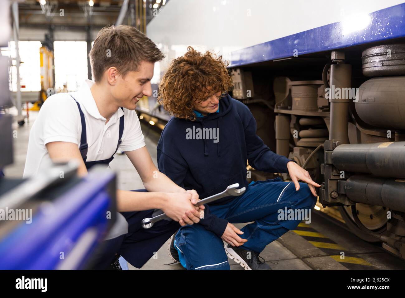 Engineer showing monorail engine to trainee in industry Stock Photo - Alamy