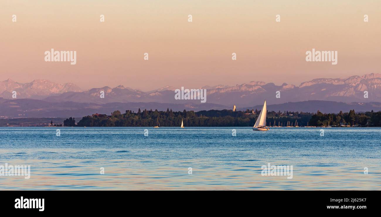 Germany, Baden-Wurttemberg, Uberlingen, Sailboats in Lake Constance at dusk with Bodanruck peninsula in background Stock Photo