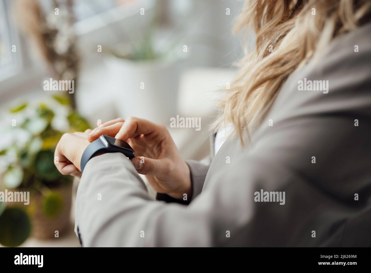 Businesswoman checking smart watch in office Stock Photo