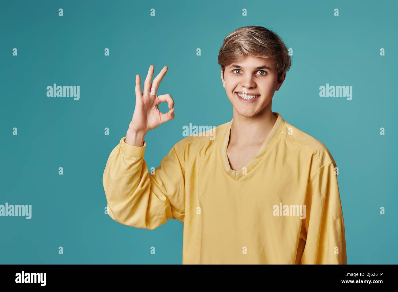 young smiling handsome guy showing Ok gesture Stock Photo