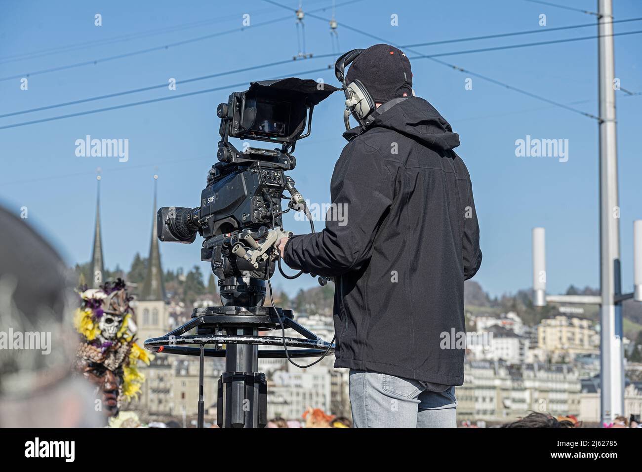 TV cameraman broadcasting the carnival parade in Lucerne, Switzerland Stock Photo