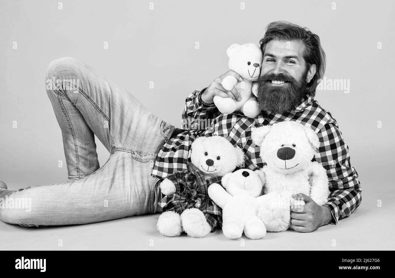 Caucasian mature hipster with trendy hairstyle in checkered shirt hold teddy bear toy, sale Stock Photo