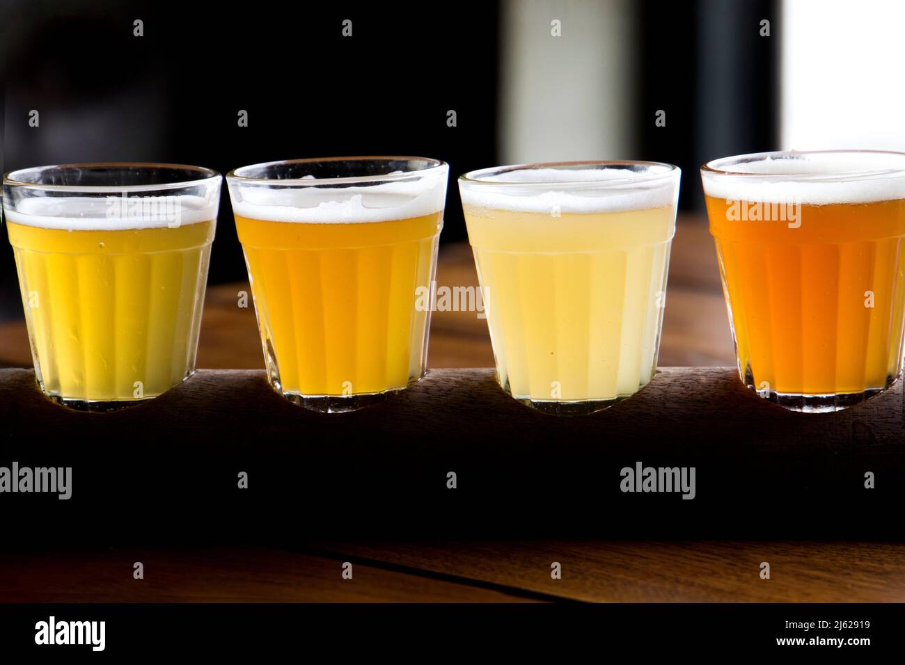 four glasses of different types of beer, draught beer, wheat beer and