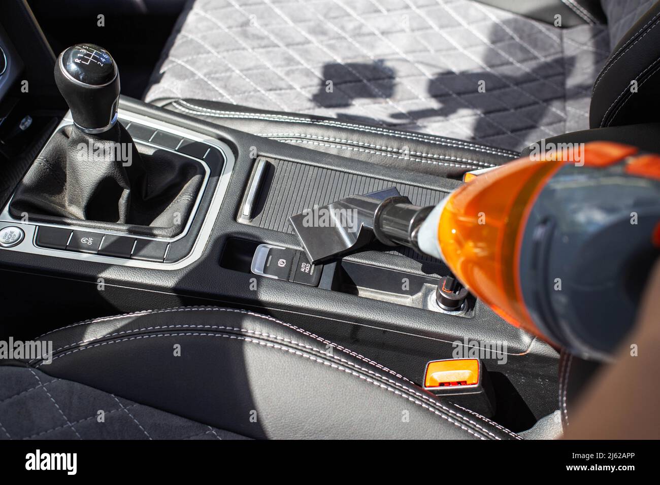 Cleaning a modern car interior with a vacuum cleaner from dirt and dust, background Stock Photo