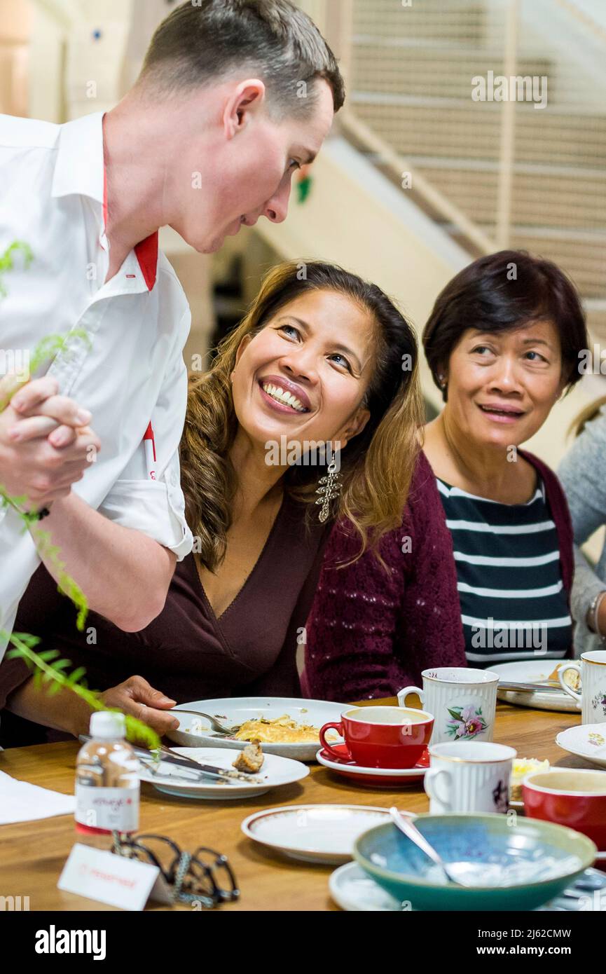 two asian woman in restaurant talk with waiter Stock Photo