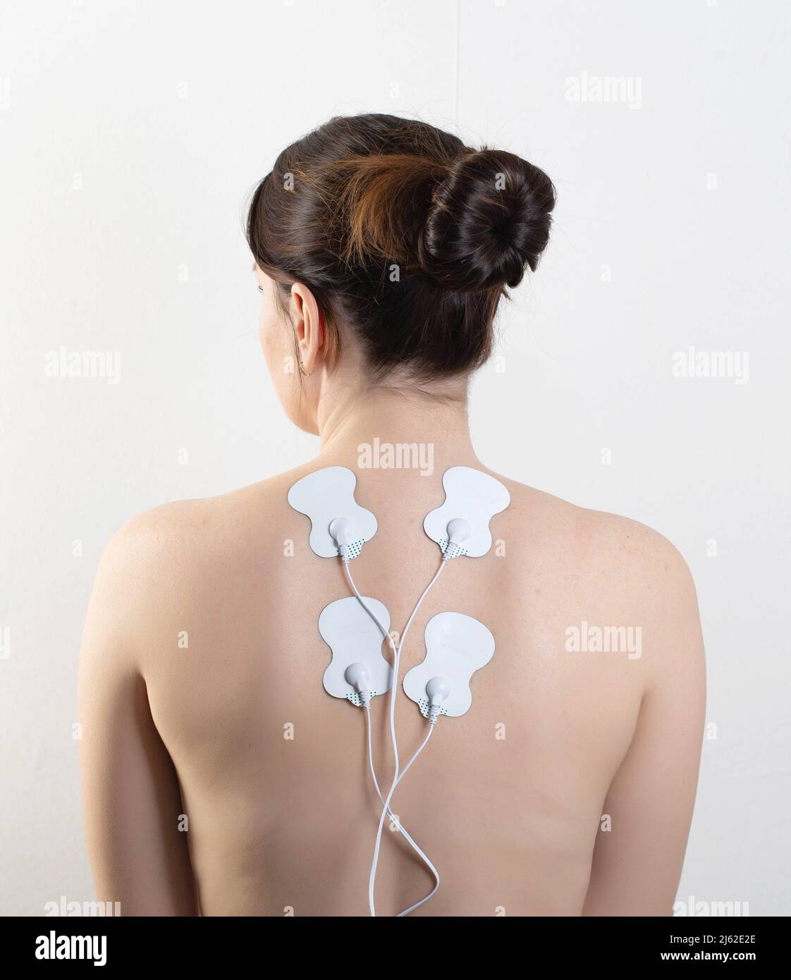 Acupuncture electronic massager on the back of a girl to relax muscles