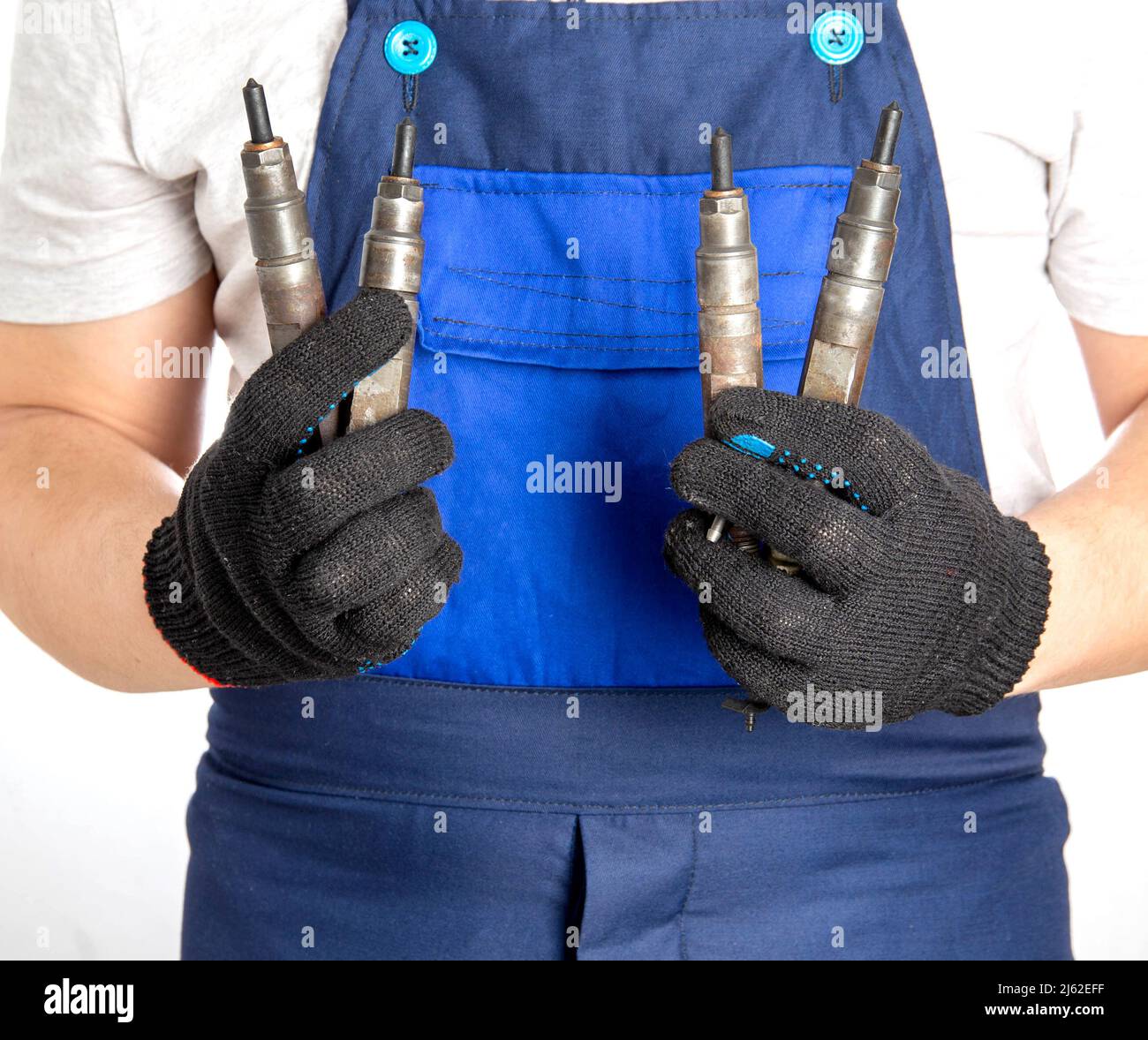 Car mechanic holds fuel car injectors in his hand. The concept of replacing and tuning the fuel