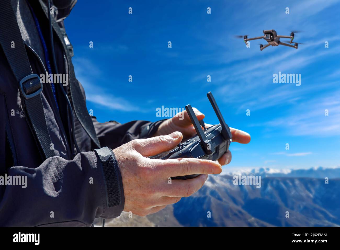 Pilot remotely controls the flight of a drone while making aerial cinematic footage Stock Photo