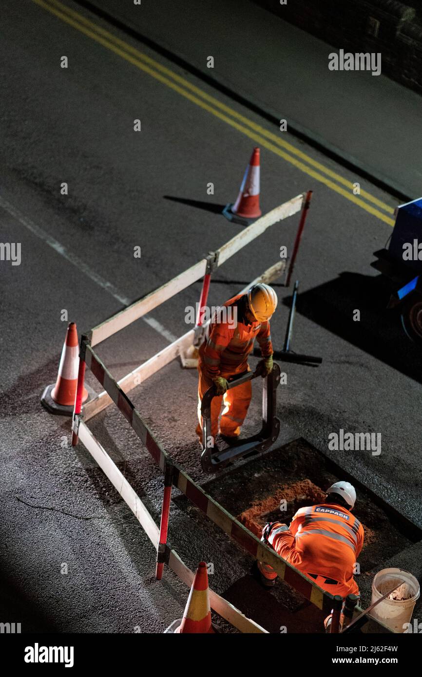 Night time roadworks, repairing a broken manhole cover in the road, in Hertfordshire, UK. Work carried out by contractors Cappagh, on behalf of Thames Water. Photo: David Levenson/Alamy Stock Photo