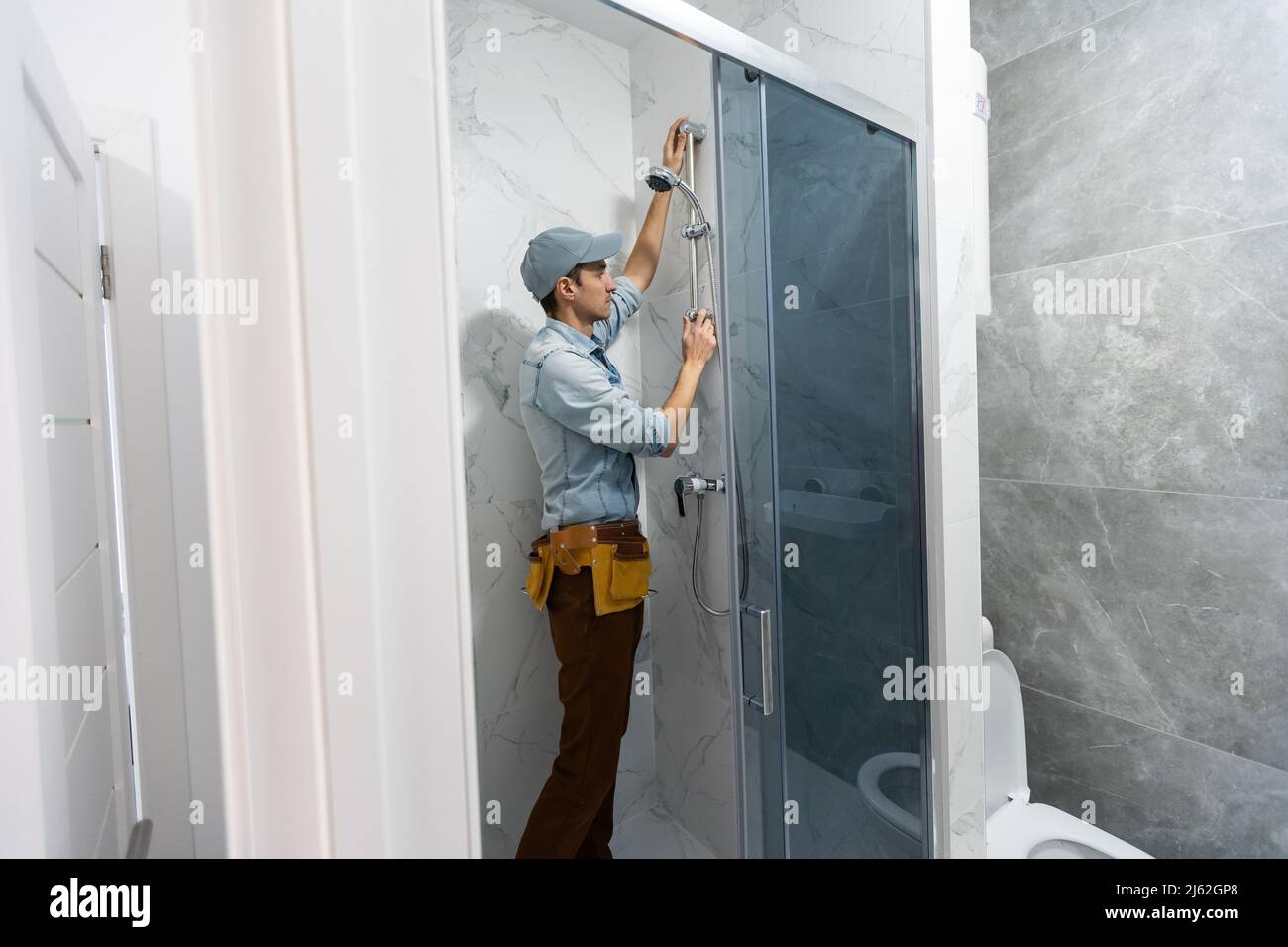 Handyman installing glass in bathroom Stock Photo Alamy