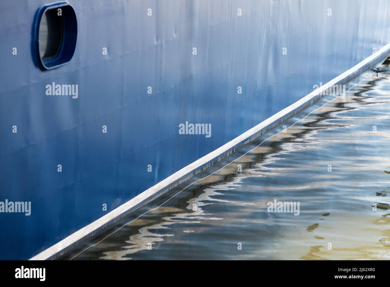 View of the blue hull of a boat and its reflection over the water at Punta del Este harbour, Maldonado, Uruguay Stock Photo