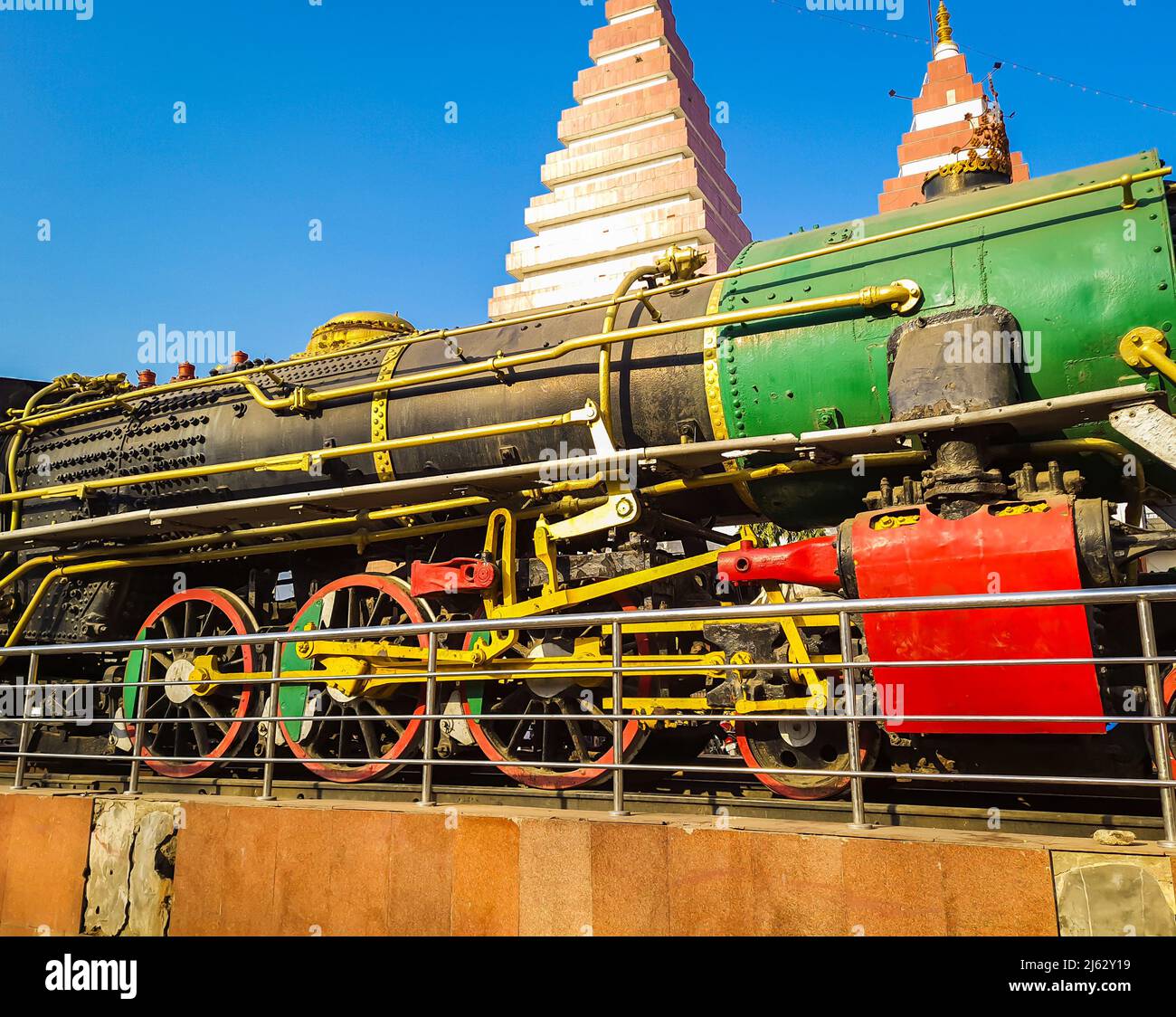 vintage steam rail engine with temple and blue sky background at day image is taken patna college patna bihar india on Apr 15 2022. Stock Photo