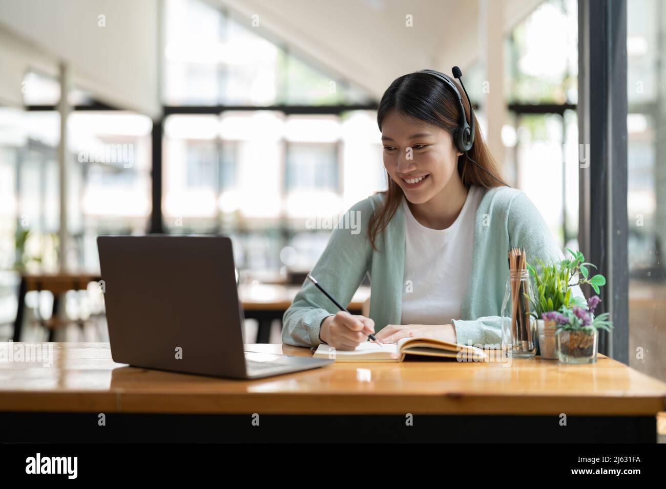 Young asian woman writing making list taking notes in notepad working
