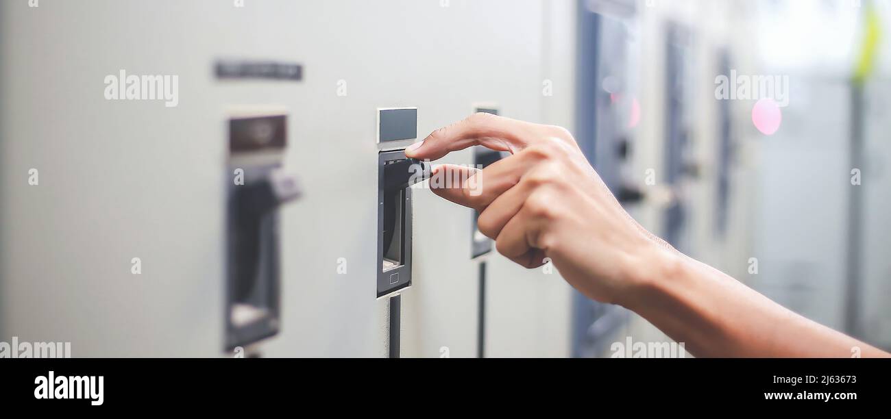 Engineers working to inspect and maintain electrical control cabinets. Stock Photo