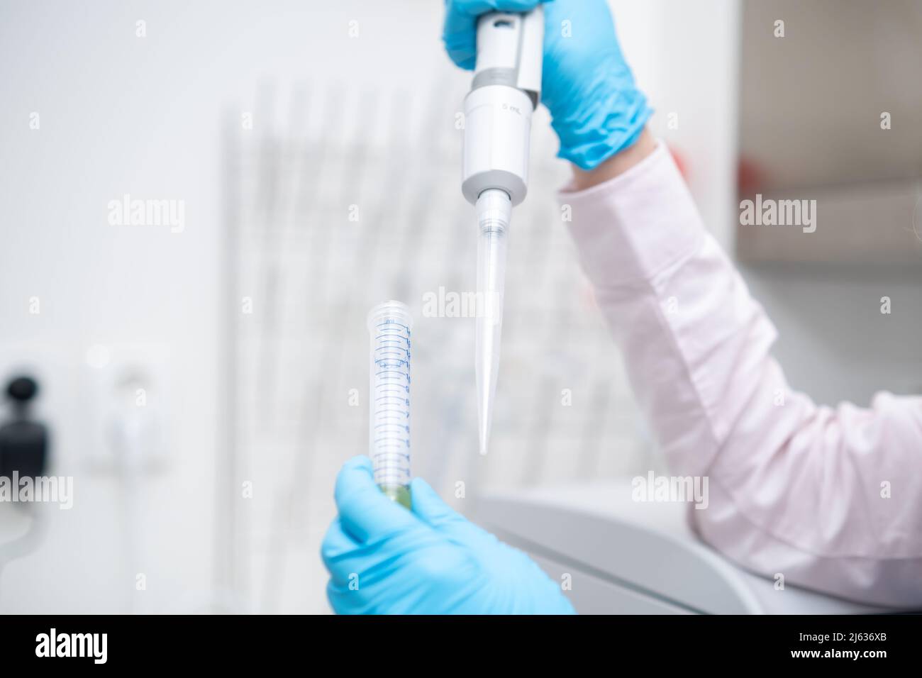 Scientist collects the sample using automatic pipette. Chemical and