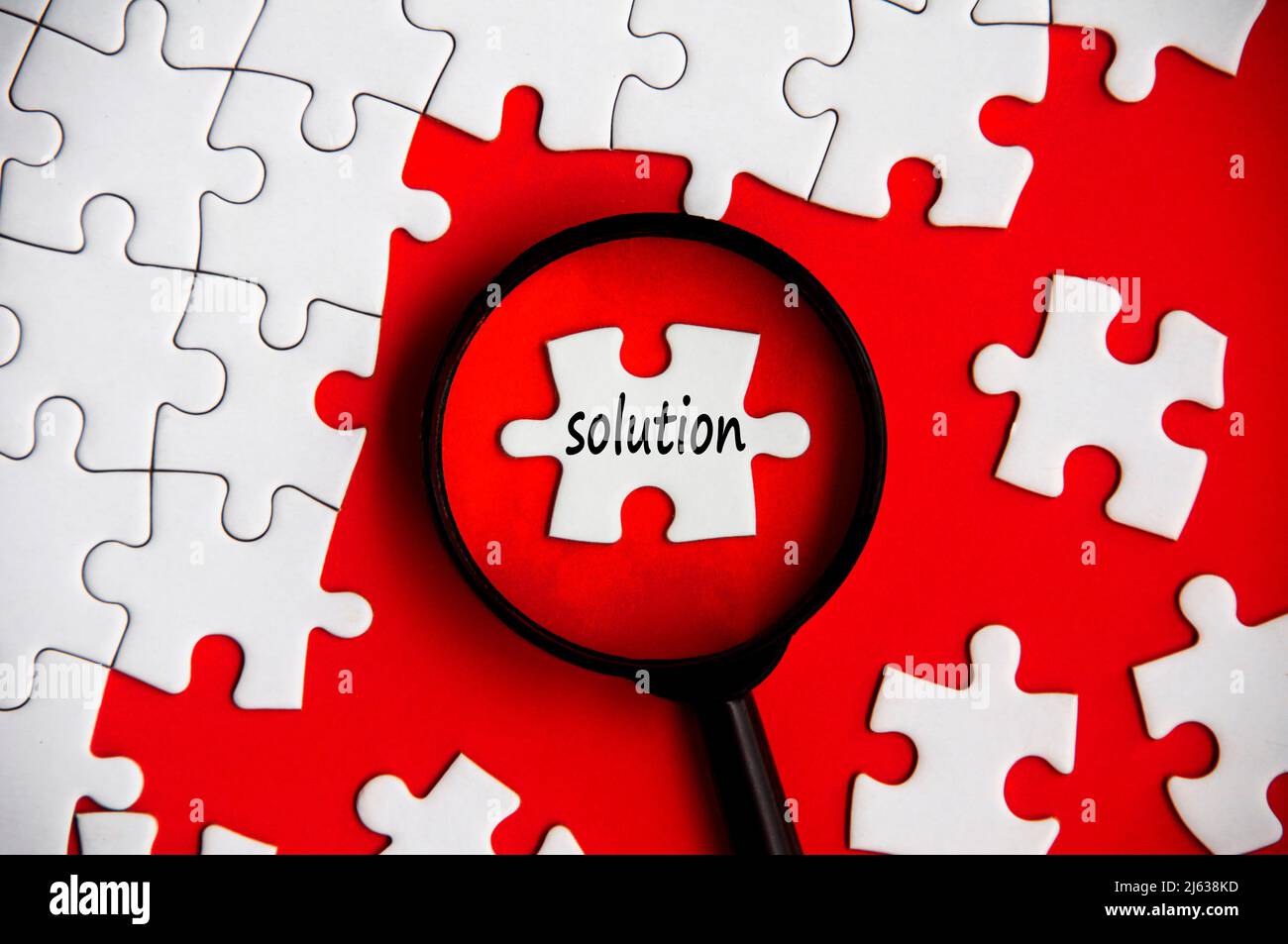 Solution text on missing jigsaw puzzle in magnifying glass Stock Photo ...